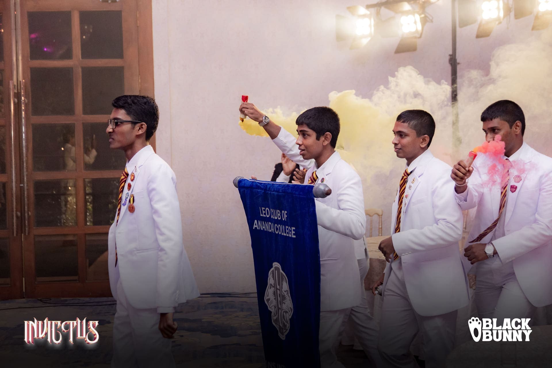 The club entering the district conference hall in procession through stage smoke