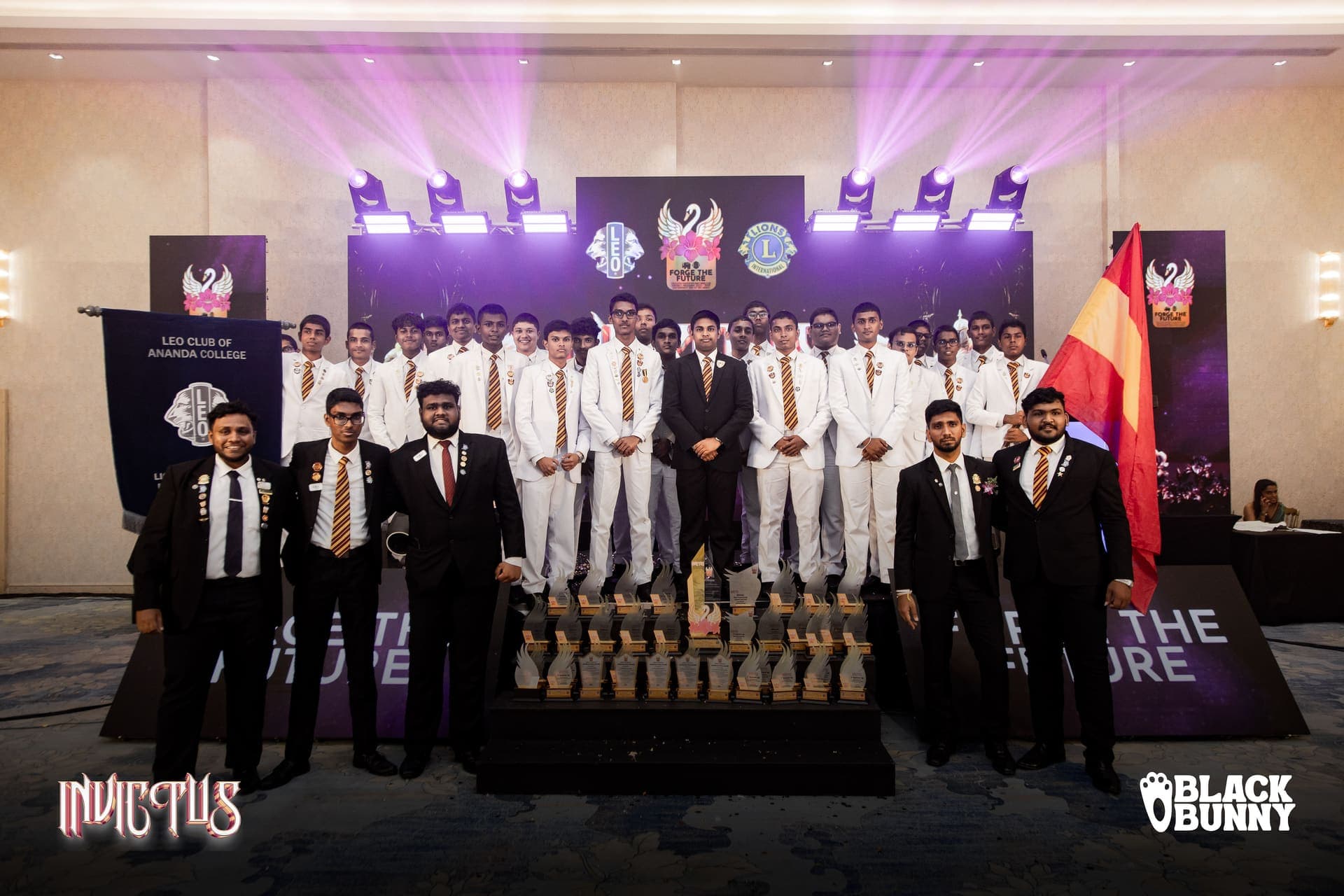 The full club photographed behind the complete set of trophies won at the District 306 D7 conference